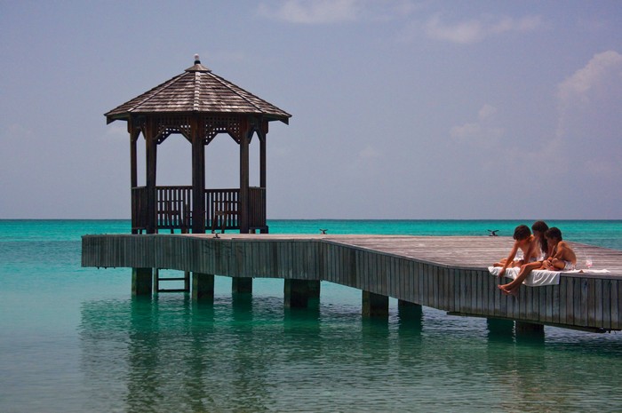 A gazebo sits on a promenade on the ocean at Jumby Bay resort