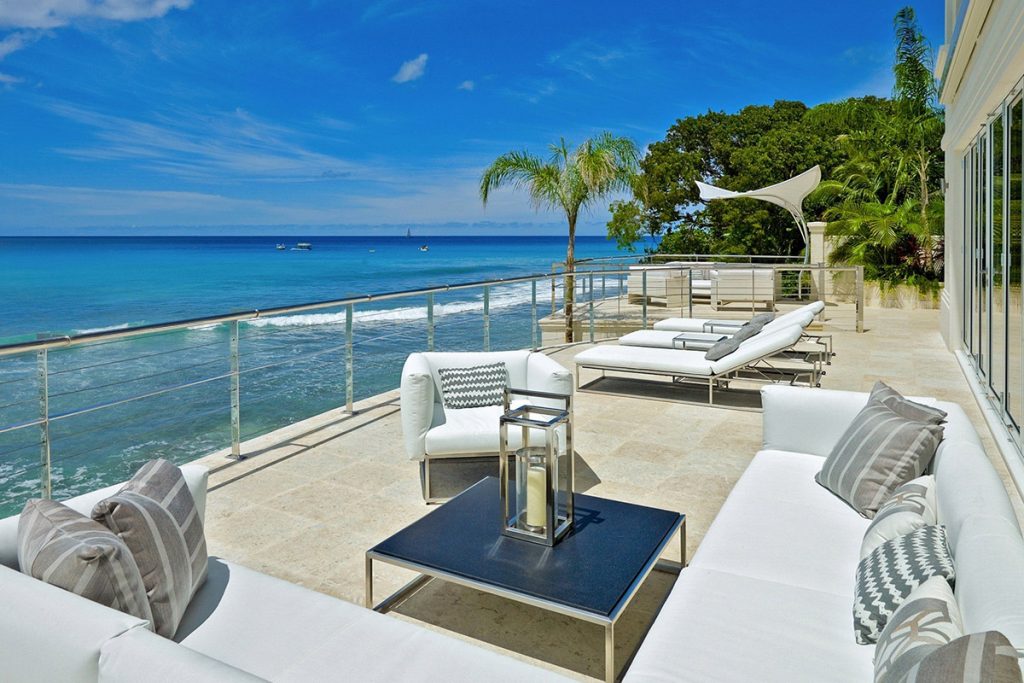 Sun deck looking out over the Caribbean Sea. Gleaming white corner sofas provide salubrious comfort. The nearby pool provides cooling down opportunities.