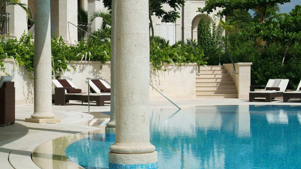 Marble pillars thrust gracefully from the intensely blue water of the swimming pool at One Sandy Lane