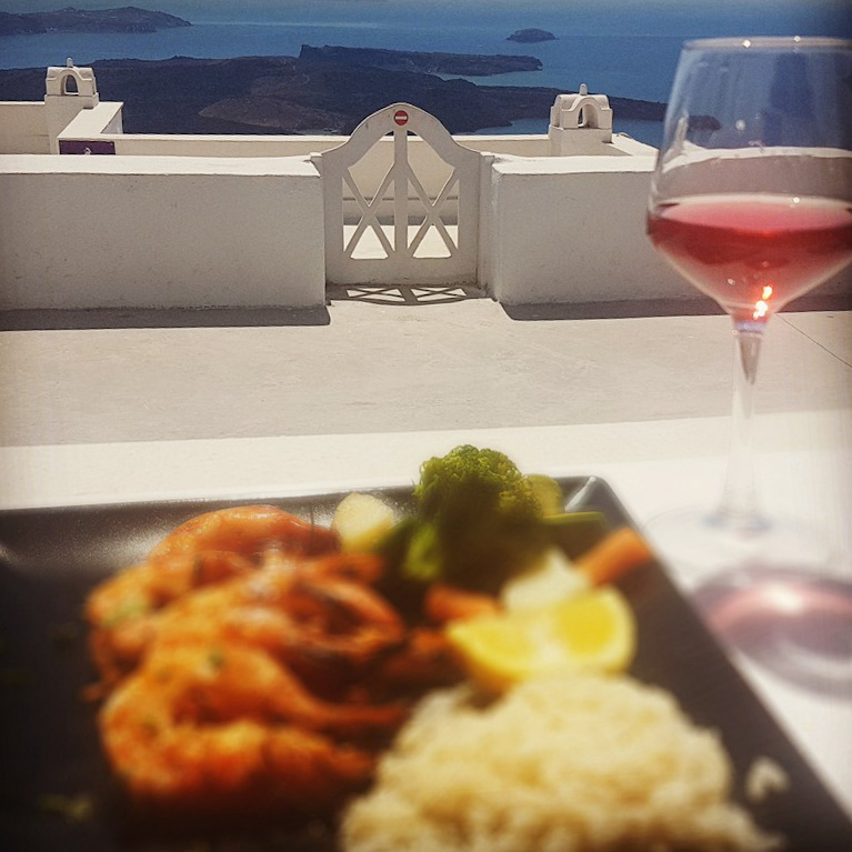 Closeup of a delicious plate of Greek seafood framed by the blue sea on the horizon