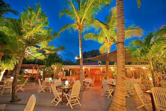 Jauntily lit palm trees push through the smooth polished decking and tower splendidly over the dining area at L'Espirit; considered to be one of the best places to eat in St Barts