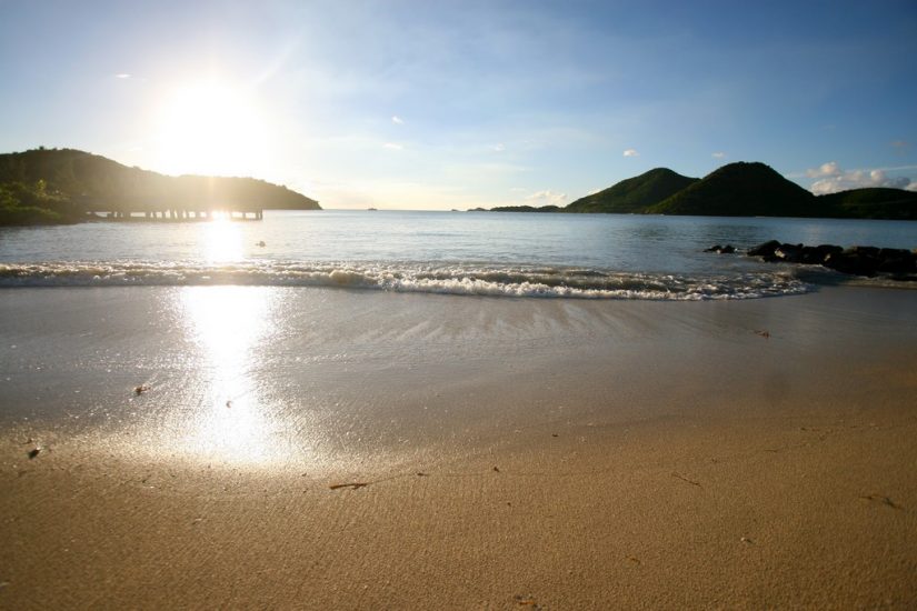 The lavish sandy shores of Jolly Beach are nestled along the coast, overlooking the glistening waters of the Caribbean Sea.