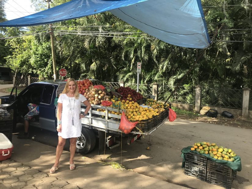 Alex poses next to a trailer full of fruit