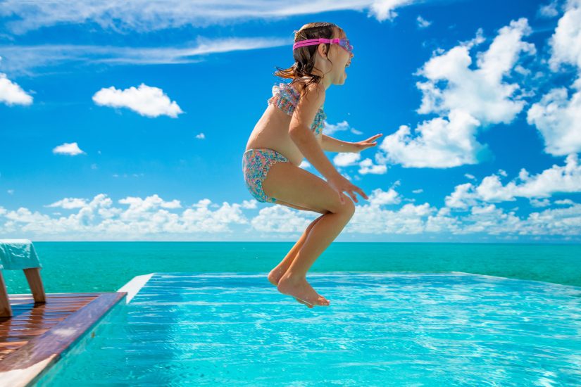 kid jumping into the pool in Turks and Caicos