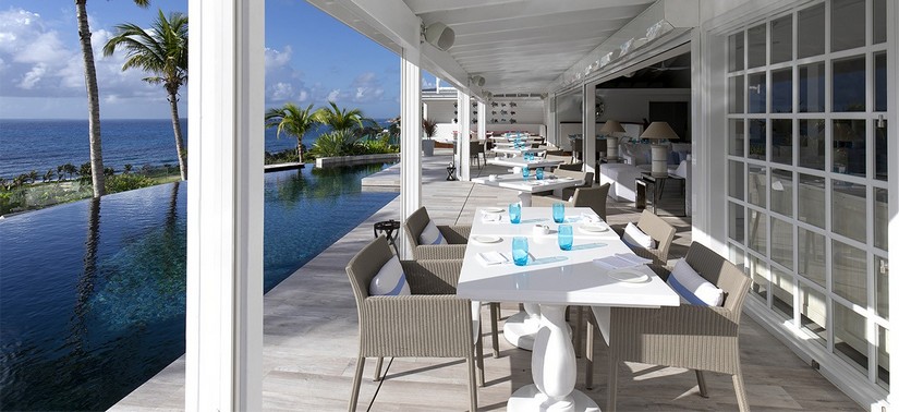 Alfresco dining area next infinity pool overlooking the Caribbean Sea at Le Toiny Restaurant in St Barts