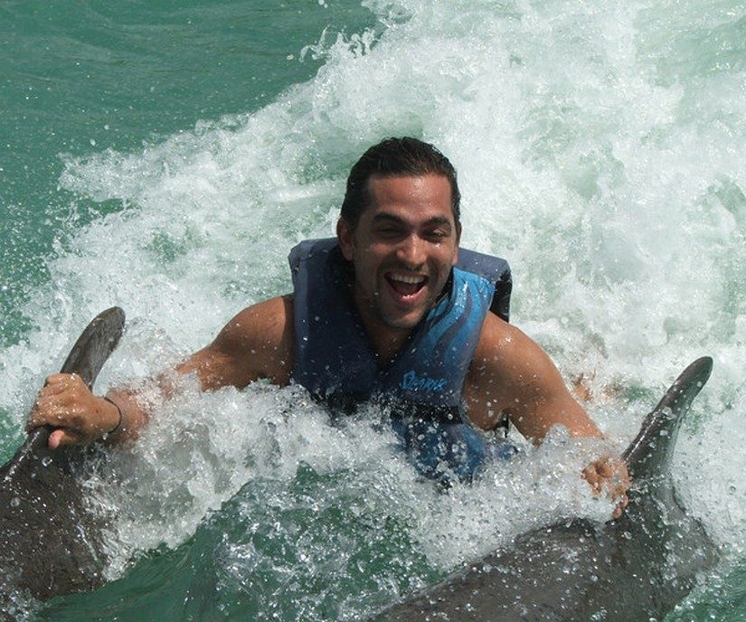 Man swimming with dolphins at half moon resort