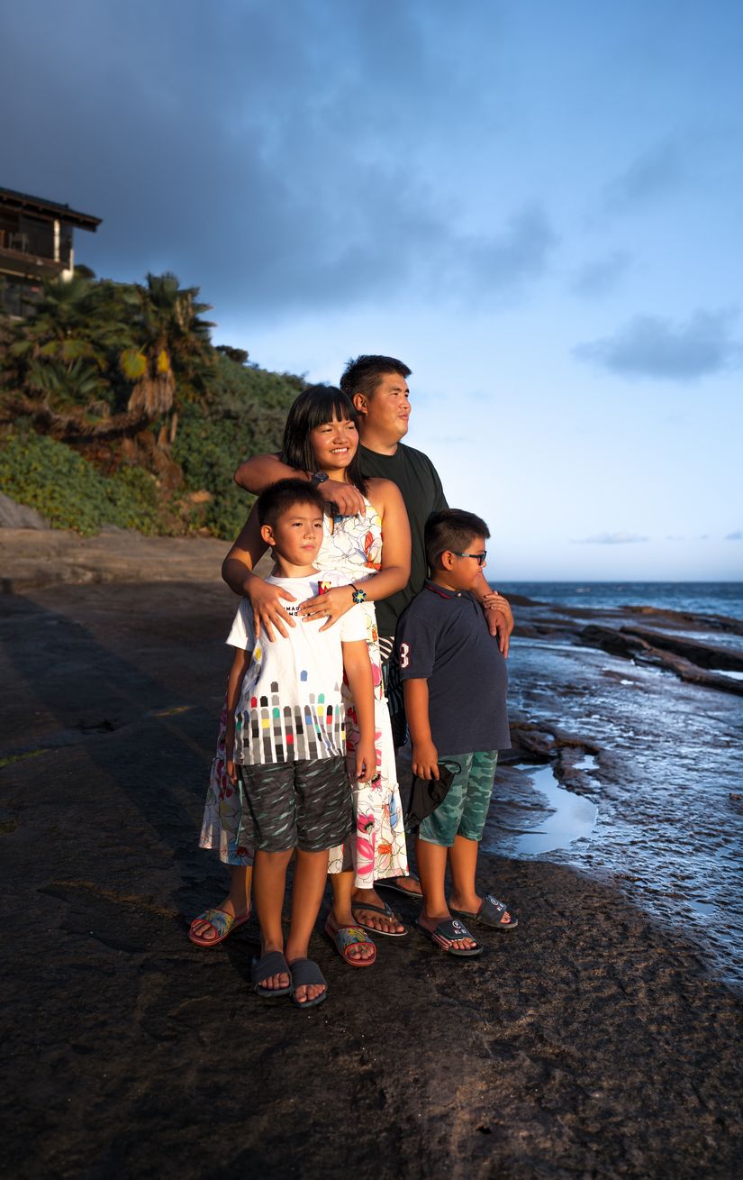 Family stands on a beach looking towards the sea in the Caribbean