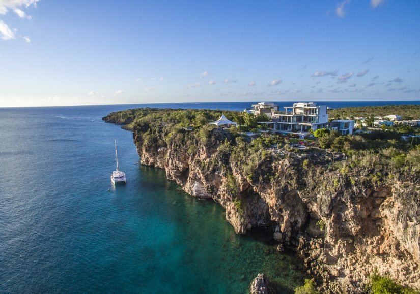A catamaran at Sea sits below Ani Private Resort in Anguilla one of the best villas in the Caribbean