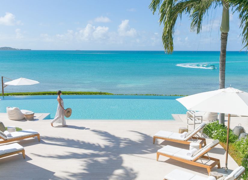 A lady walks on the terrace at Calabash villa jumby bay resort antigua