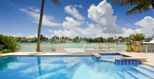 Pool area, palm trees and a vast amount of blue sky at a villa in Maimi