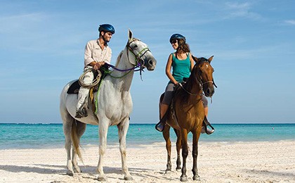 A couple enjoy horse riding on their vacation to Cap Cana Horse Riding at the Cap Cana luxury resort