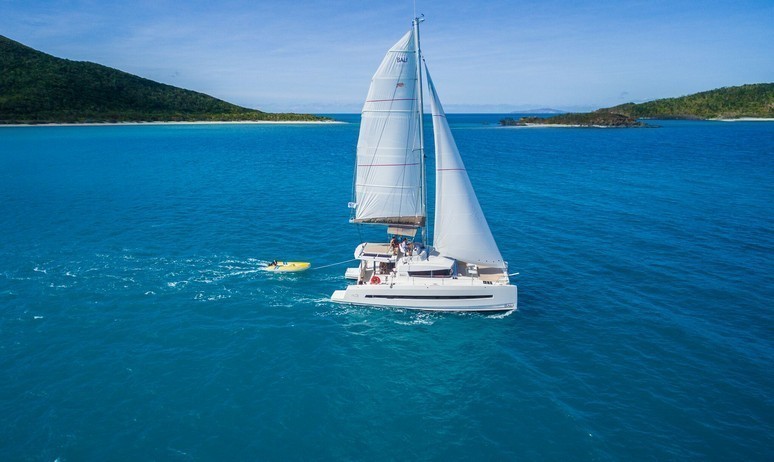 A luxury yacht charter catamaran cruises gracefully through the Caribbean sea