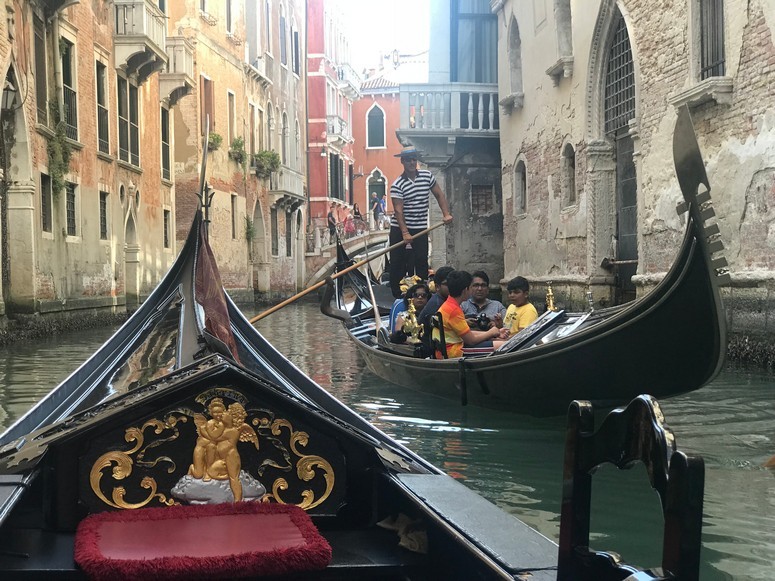 View from a Gondola moving through a canal in Venice