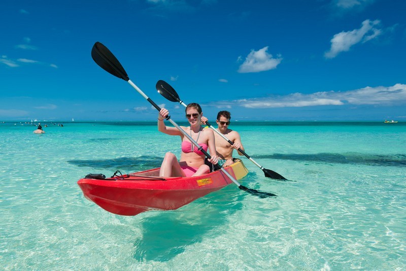 A man and a woman kayak in shallow water off COMO Parrot Cay in Turks and Caicos