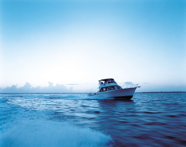 A white fishing yacht plys the waves of the Caribbean Sea