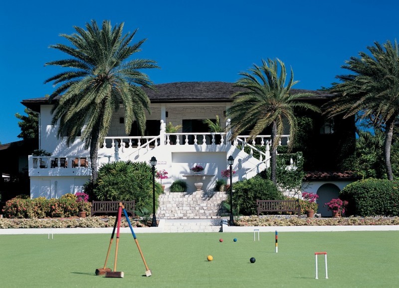 Three croquet mallets balanced together on the croquet lawn at Jumby Bay