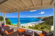 Covered outdoor seating area overlooking the sea and beach from the elevated position of Villa Solei