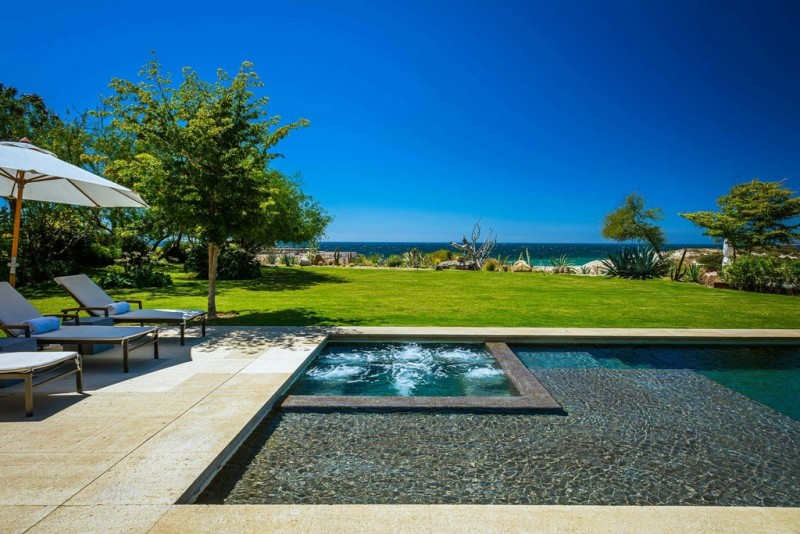 View of the outdoor pool and garden overlooking the sea