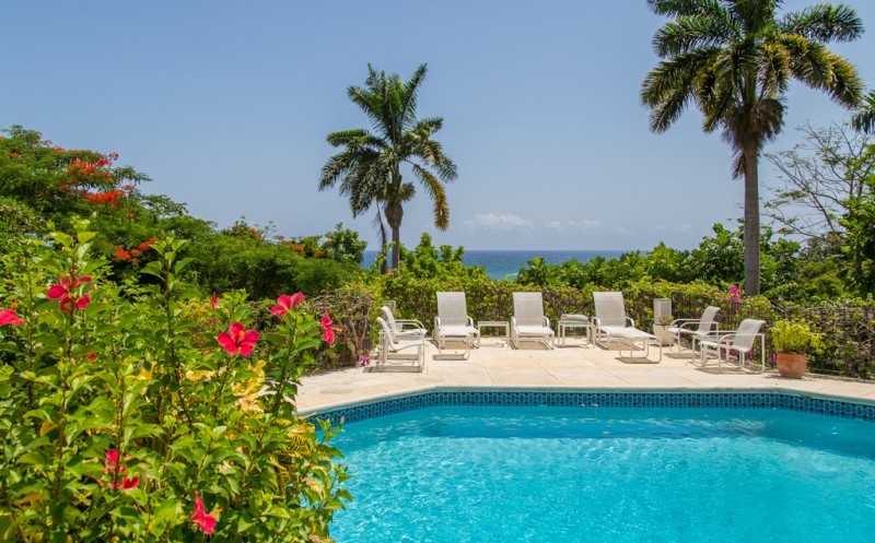 Sunloungers around the pool, with views of the ocean