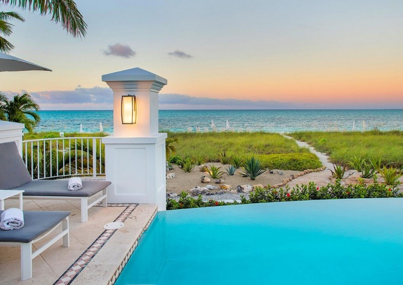 View of the pool, the beach and the sea beyond in the evenin