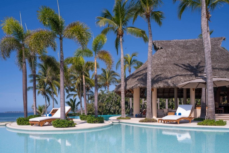 View of the infinity pool, sunbeds and gazebo.