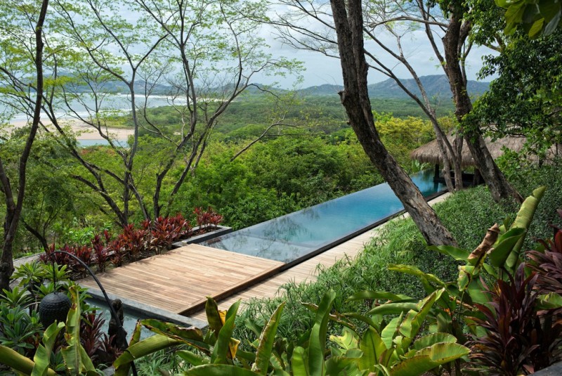 View of pool and beach and sea below from a villa
