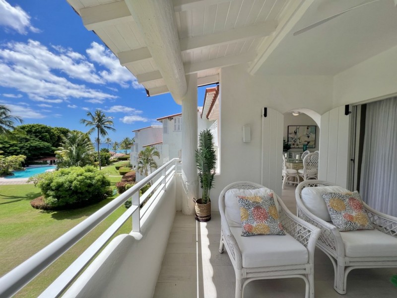 Balcony with chairs and view to the garden and pool