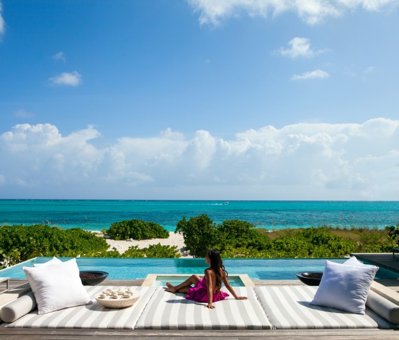 Lady by the pool side and beach view at Graceful Living