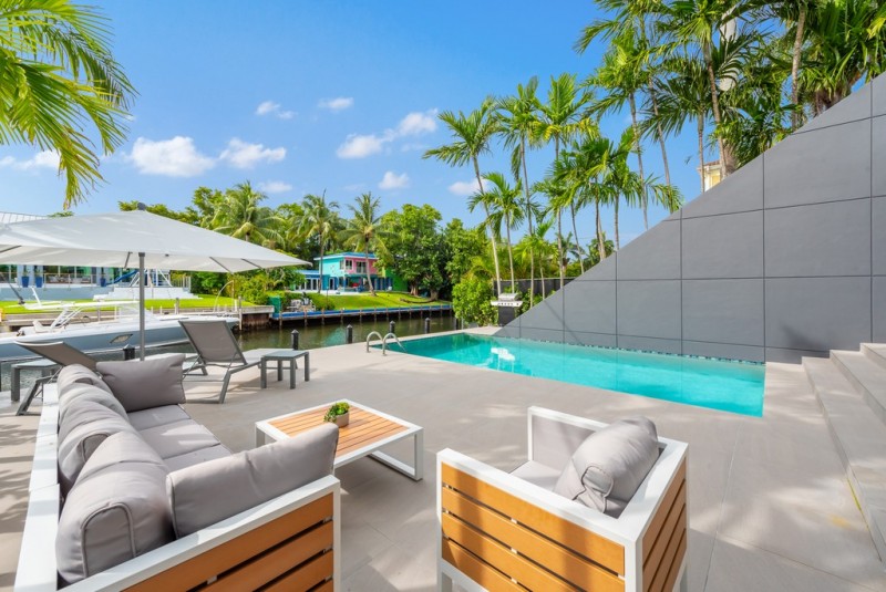 View of the pool deck with the sitting area, loungers and ca