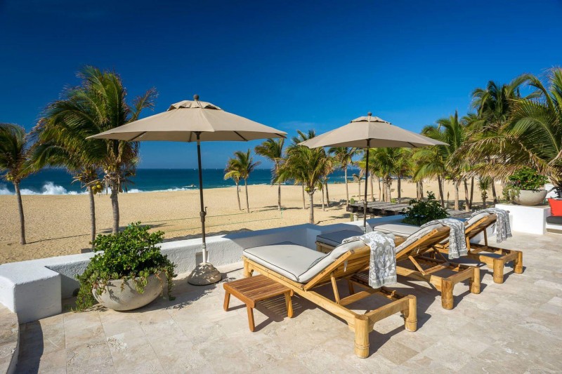 A view of the beach and the blue sea, with sunbeds and sun u