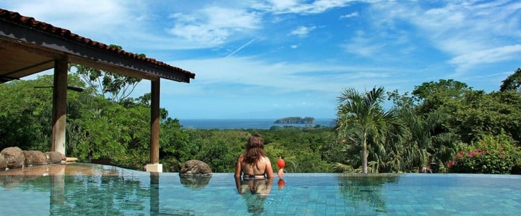 A girl in the infinity pool overlooking the forest at Villa Buena