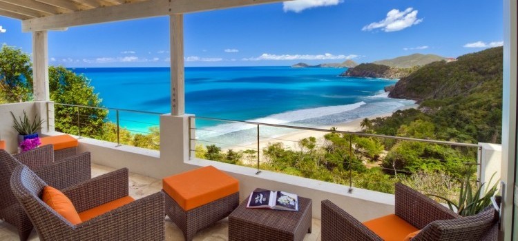 Covered outdoor seating area overlooking the sea and beach from the elevated position of Villa Solei